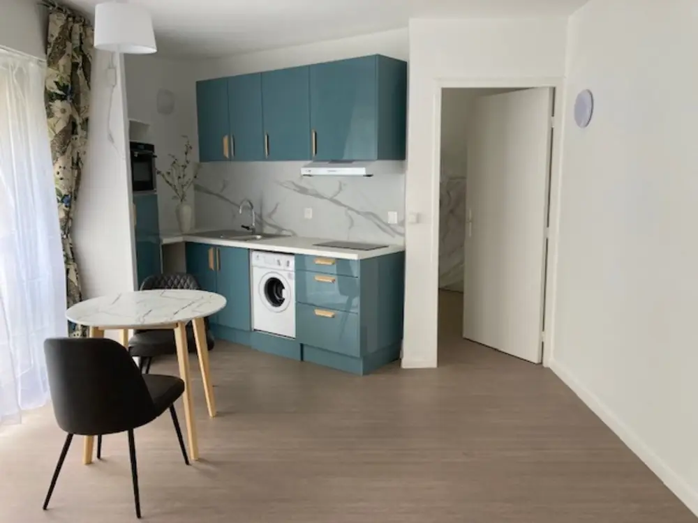 Cuisine équipée du logement, façades bleu-vert.